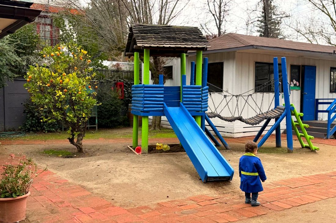 Juegos infantiles del jardín entre árboles